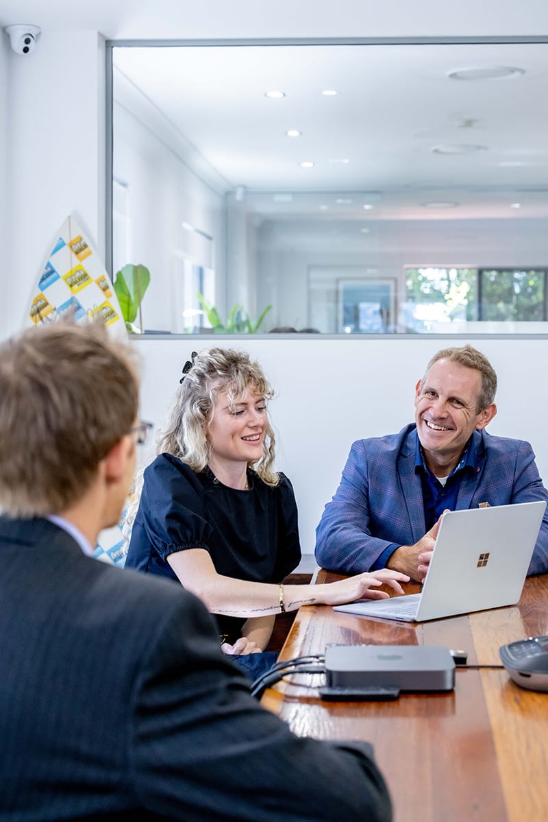 Researchers and business people working on a laptop computer in a meeting room